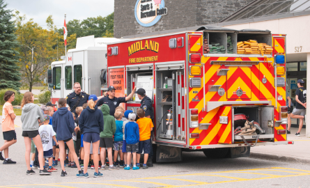 kids standing and looking at fire truck