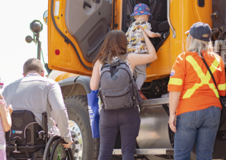Woman lifting small child into truck
