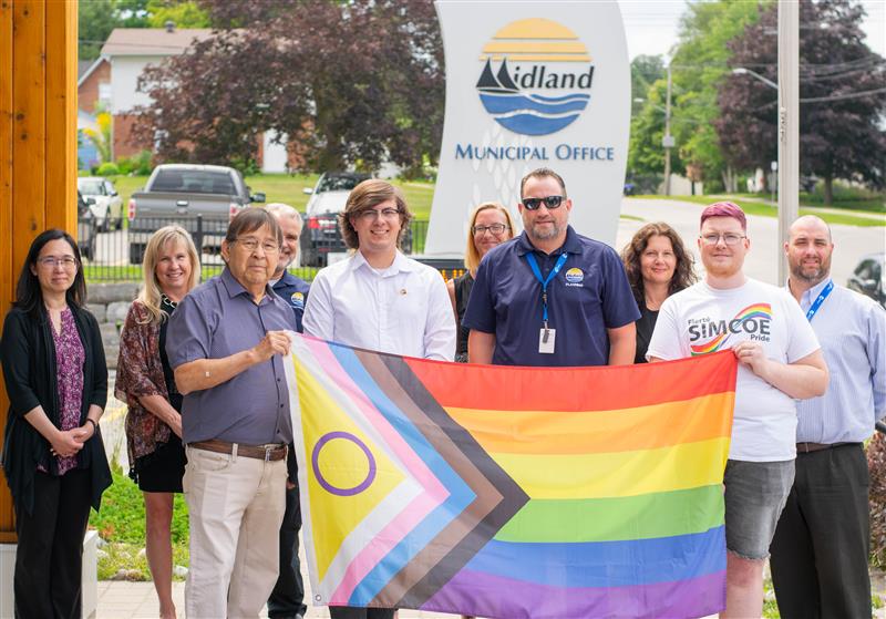 Fierté Simcoe Pride flag raising People standing with Flag