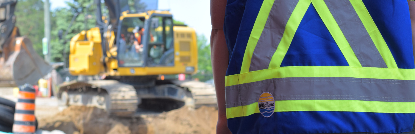 Midland safety vest with construction machinery in background