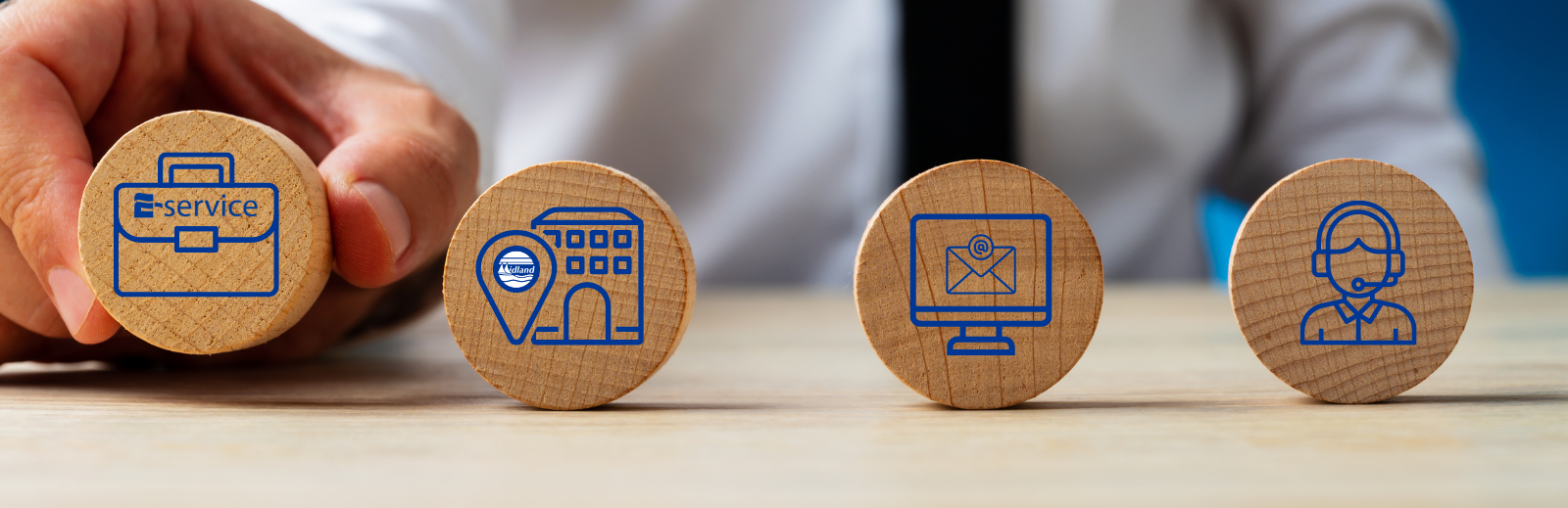 Hand holding wooden block with an icon, to the left are three more wooden block with icons