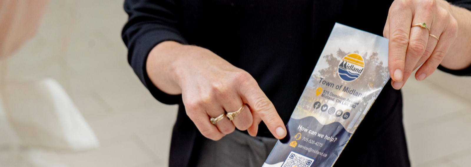 holding a brochure and pointing