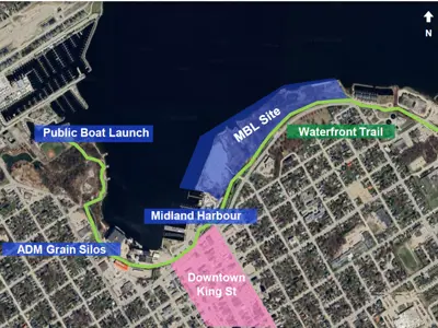 A satellite map of Midland’s waterfront highlighting the proposed MBL site in blue, a green route along the shoreline labeled “Waterfront Trail,” and key locations including Midland Harbour, the public boat launch, and ADM grain silos. A pink section marks the downtown King Street area, with roads and neighbourhoods visible throughout.